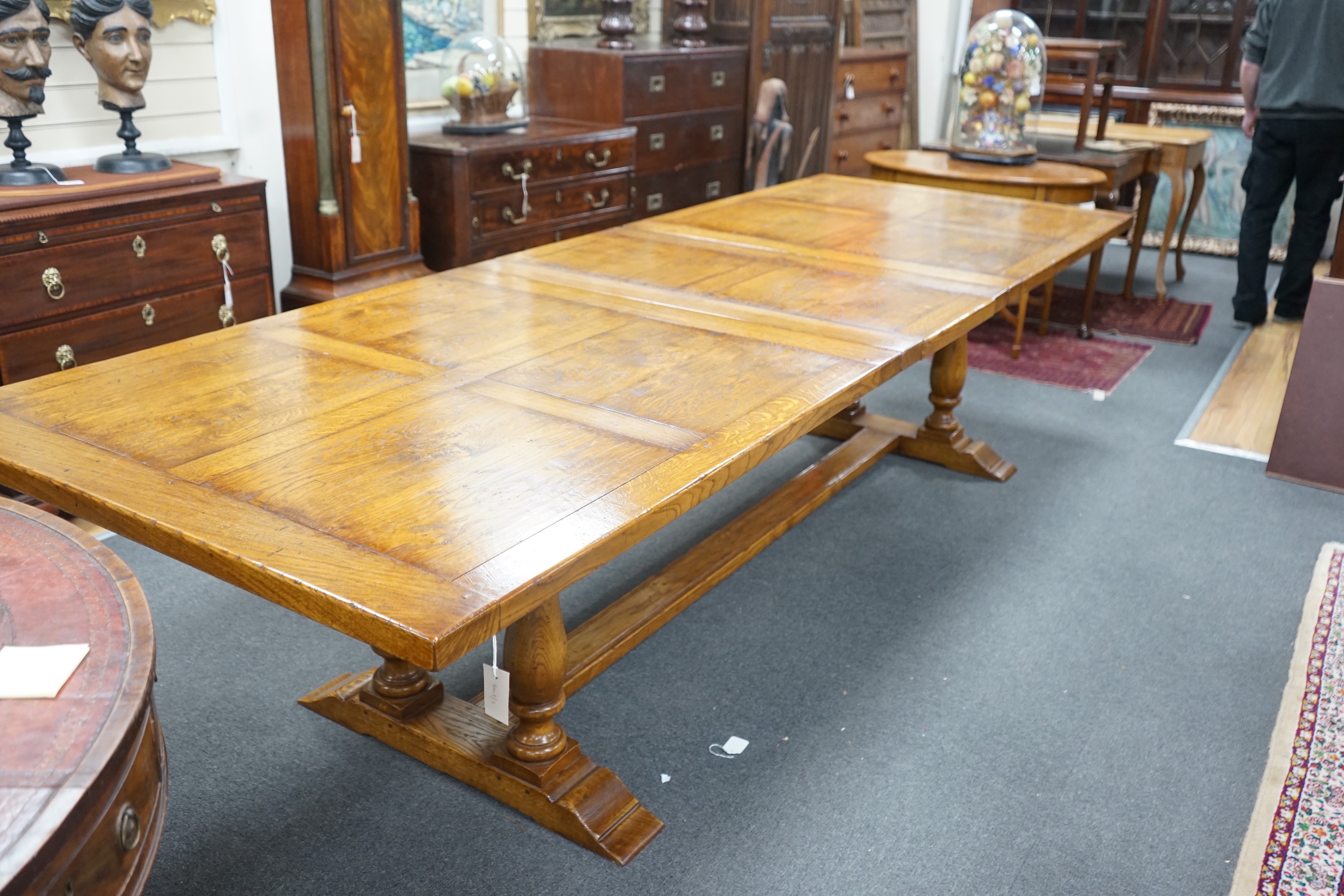 A reproduction 18th century style oak extending refectory dining table, length 306cm extended, one spare leaf, width 106cm, height 75cm
